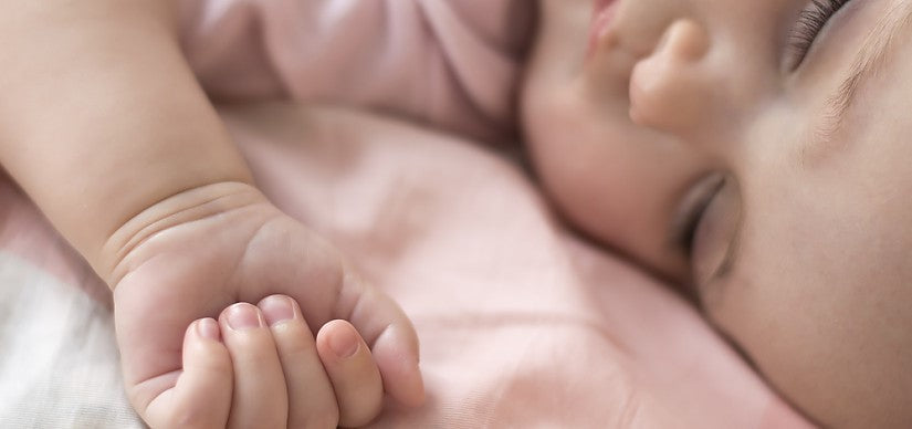 Un parent tient bébé en position verticale après le repas